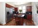 Modern kitchen featuring dark wood cabinets, black countertops, stainless steel appliances and central island with seating at 530 N Mcdowell St, Charlotte, NC 28204