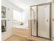 Bright bathroom featuring a tub with tile surround and a glass-enclosed shower at 6520 Fieldstone Manor Dr, Matthews, NC 28105