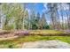 Beautiful backyard featuring mature trees, brick retaining walls, and a well-maintained lawn at 6548 Robin Hollow Dr, Mint Hill, NC 28227