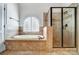 Bright bathroom with tub, tiled shower, and arched window at 6548 Robin Hollow Dr, Mint Hill, NC 28227
