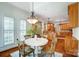 Open dining area with hardwood floors, white table, and view of the kitchen at 6548 Robin Hollow Dr, Mint Hill, NC 28227