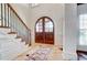 Elegant foyer with staircase, wood railing, tile flooring and arched double-door entry at 6548 Robin Hollow Dr, Mint Hill, NC 28227