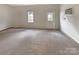Spacious living room with carpet flooring, ample natural light, and a back door at 7829 Buddy Holly Rd, Charlotte, NC 28216