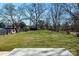 A spacious backyard covered with green grass and bare trees in the background at 81 Kirk St, Salisbury, NC 28144