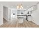 Open kitchen with white cabinetry, stainless appliances, granite counters, an island, and wood floor at 81 Kirk St, Salisbury, NC 28144