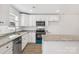 White kitchen featuring stainless steel appliances, an island with granite countertops, and wood floor at 81 Kirk St, Salisbury, NC 28144