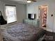 Cozy bedroom with gray comforter, light dresser, and adjacent bathroom at 827 W Horah St, Salisbury, NC 28144