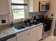Featuring a stainless steel microwave, double sink, granite counters, and natural light from the window, this kitchen is efficient at 827 W Horah St, Salisbury, NC 28144