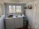 Bright laundry room with a large window, modern washer and dryer, and storage for laundry supplies, making chores easier at 827 W Horah St, Salisbury, NC 28144