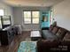 Cozy living room featuring hardwood floors, a comfortable couch, and a bright turquoise front door at 827 W Horah St, Salisbury, NC 28144