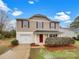 Charming two-story home featuring neutral siding, red shutters and front door, a single car garage and a well-manicured front yard at 845 Finley Rd, Rock Hill, SC 29730