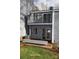 View of the backyard, showcasing a small patio with a sliding glass door and a balcony above at 9129 Troon Ln # C, Charlotte, NC 28214