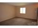 Neutrally painted bedroom with carpet and a window that lets in natural light at 9129 Troon Ln # C, Charlotte, NC 28214