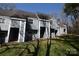 Townhouse featuring gray siding, front entryway with steps, and green grassy lawn at 9129 Troon Ln # C, Charlotte, NC 28214