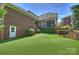 Spacious backyard with lush lawn, brick accents, and a charming screened porch at 100 Cliveden Ct, Belmont, NC 28012