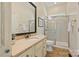 Bathroom with walk-in shower, tan cabinets, large mirror, and neutral tile flooring creating a functional space at 100 Cliveden Ct, Belmont, NC 28012