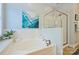 Bathroom featuring a white tub, glass-enclosed shower, neutral wall color, and a white tile border at 100 Cliveden Ct, Belmont, NC 28012