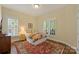 Cozy bedroom with warm-toned rug, a comfy bed with floral bedding, and plantation shutters for privacy at 100 Cliveden Ct, Belmont, NC 28012