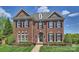 Elegant brick home featuring a manicured lawn, symmetrical design, and black shutters under a partly cloudy sky at 100 Cliveden Ct, Belmont, NC 28012