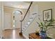 Bright foyer featuring hardwood floors, a staircase with white railings, and arched transom window above the front door at 100 Cliveden Ct, Belmont, NC 28012