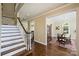 Open foyer showcasing hardwood floors, a staircase, and an entryway leading to a dining room with large windows at 100 Cliveden Ct, Belmont, NC 28012