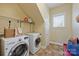 Functional laundry room with modern washer and dryer, ample storage, and natural light at 100 Cliveden Ct, Belmont, NC 28012