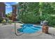 Inviting in-ground pool surrounded by mature trees and lush landscaping creates a private oasis at 100 Cliveden Ct, Belmont, NC 28012