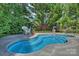 In-ground pool featuring a brick accent wall, coping, and garden views at 100 Cliveden Ct, Belmont, NC 28012