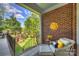Inviting porch with brick wall, sun decor, and comfortable seating overlooking manicured backyard at 100 Cliveden Ct, Belmont, NC 28012