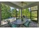 Relaxing screened porch with outdoor dining set and views of the lush backyard and pool at 100 Cliveden Ct, Belmont, NC 28012