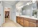 Bright bathroom with double vanity, wood cabinets, and a walk-in closet for ample storage at 10014 Berkeley Castle Dr, Charlotte, NC 28273