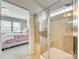 Modern bathroom featuring tiled shower with glass door and a glimpse into the bedroom for added convenience at 10014 Berkeley Castle Dr, Charlotte, NC 28273
