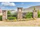Stone community entrance with manicured landscaping, seasonal flowers, and a black metal fence at 10014 Berkeley Castle Dr, Charlotte, NC 28273