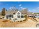 Aerial view of an elegant brick home with outdoor seating, patio, landscaping, and pergola at 10014 Berkeley Castle Dr, Charlotte, NC 28273