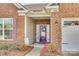 Inviting front entryway with a decorative wreath, brick facade, and manicured landscaping at 10014 Berkeley Castle Dr, Charlotte, NC 28273