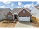 Charming front exterior showcasing brick facade, two-car garage, and neatly landscaped front yard at 10014 Berkeley Castle Dr, Charlotte, NC 28273