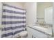 Bathroom with a shower featuring striped curtain, granite countertop, and modern fixtures, creating a refreshing space at 1006 W B St, Kannapolis, NC 28081