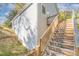 Exterior view of home with stairs leading to a deck, complemented by a natural landscape at 1006 W B St, Kannapolis, NC 28081