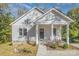 Charming home featuring a covered front porch with white columns and vertical siding at 1006 W B St, Kannapolis, NC 28081