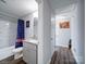 Bathroom featuring modern vanity and shower/tub combo, plus access to hallway at 108 Oak Grove St, Kannapolis, NC 28081