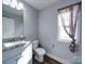 Well-lit bathroom featuring a granite countertop vanity, toilet, and modern accents at 108 Oak Grove St, Kannapolis, NC 28081