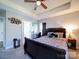 Comfortable bedroom with tray ceiling, ceiling fan, a cozy bed, and ensuite bathroom at 108 Oak Grove St, Kannapolis, NC 28081