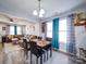 Open-concept dining area with a view to the living room and large windows with bright blue curtains at 108 Oak Grove St, Kannapolis, NC 28081