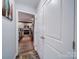 Hallway view into kitchen reveals stainless appliances, white cabinets, and wood flooring at 108 Oak Grove St, Kannapolis, NC 28081