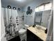 Well-lit bathroom with a shower-tub combo and a vanity with granite countertop and framed mirror at 109 Stroupe Rd # E, Gastonia, NC 28056