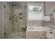 Bathroom featuring a glass shower, soaking tub, and window that provides natural light at 11001 Valley Spring Dr, Charlotte, NC 28277