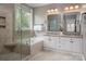 Bright bathroom featuring a soaking tub, glass shower, double vanity, and neutral tile throughout at 11001 Valley Spring Dr, Charlotte, NC 28277