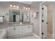 Bathroom with double vanity with granite counters, framed mirrors and white cabinets at 11001 Valley Spring Dr, Charlotte, NC 28277