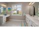 Bright bathroom with dual vanities, white cabinets, natural light, and tiled flooring at 11001 Valley Spring Dr, Charlotte, NC 28277