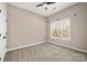 Bright bedroom with neutral paint and carpet, a ceiling fan, and a large window offering plenty of natural light at 11001 Valley Spring Dr, Charlotte, NC 28277
